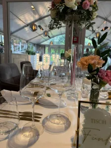 Blick auf die festlich dekorierten Tische und den stilvollen Anbau im Clostermanns Hof Niederkassel während einer Hochzeit, begleitet von Music DJ Chris.