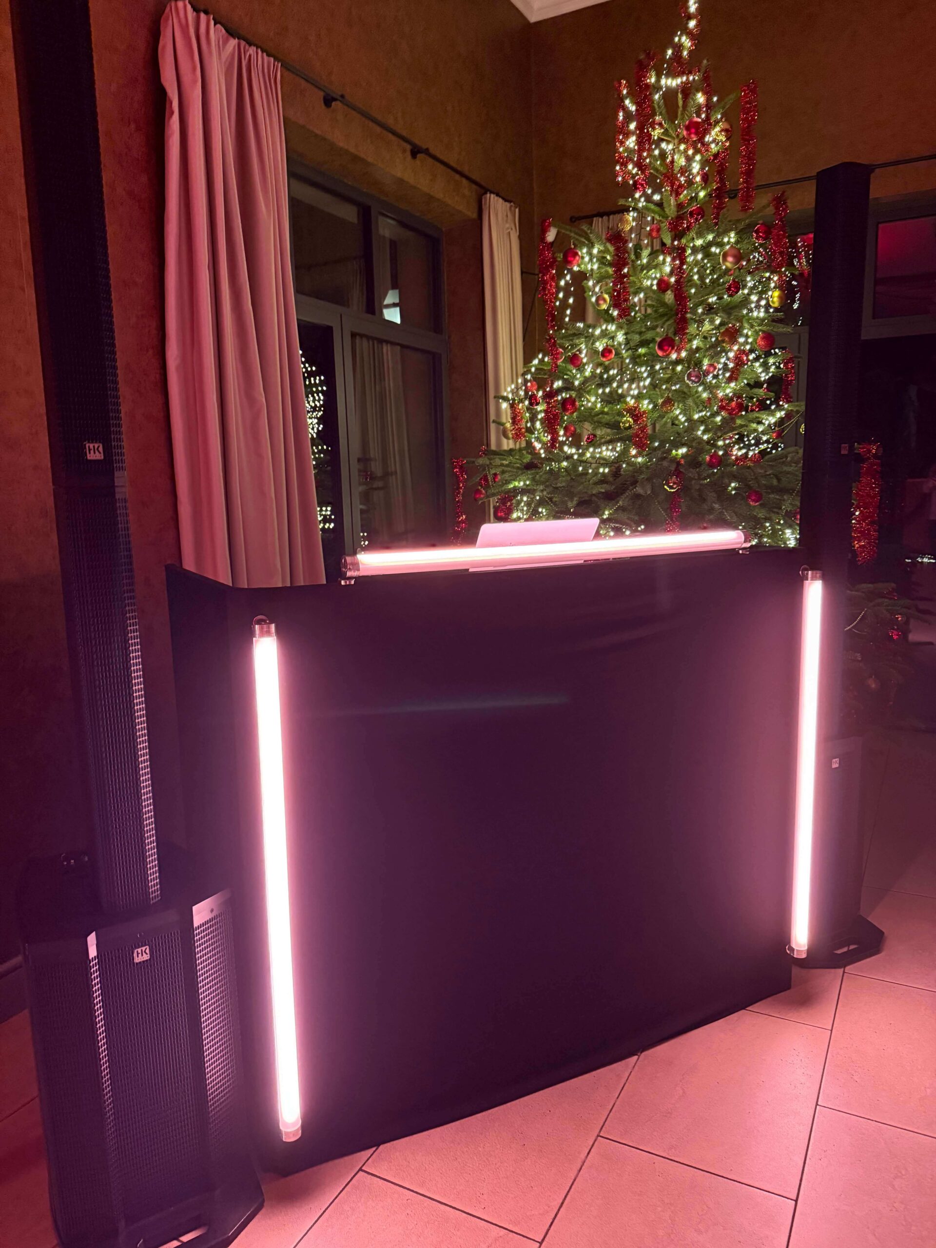 DJ Chris Weihnachtsfeier: DJ-Tisch mit Tontechnik, Ape Labs Neon Tube 6 Pix und Weihnachtsbaum