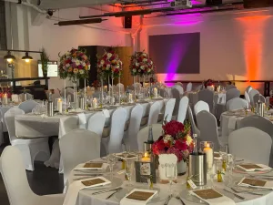 Hochzeitsdekoration in der Feuerhalle Euskirchen mit stilvoll beleuchteten Tischen und moderner Lichttechnik