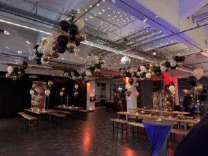 Raumdekoration mit bunten Luftballons an Decke und Tischen bei einer Mottoparty in der Feuerhalle Euskirchen