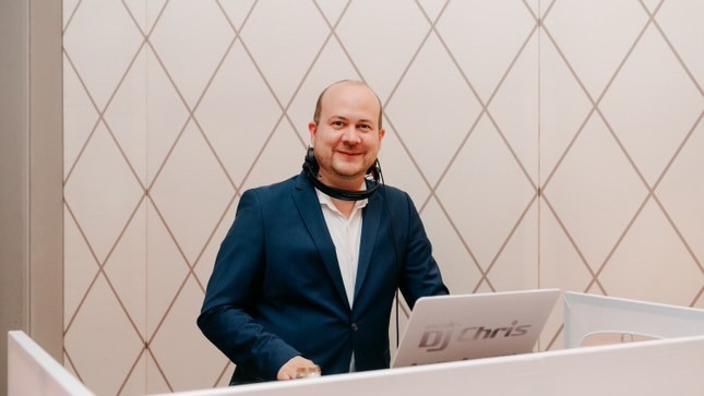 Music DJ Chris steht bei einer Veranstaltung hinter seinem DJ-Pult