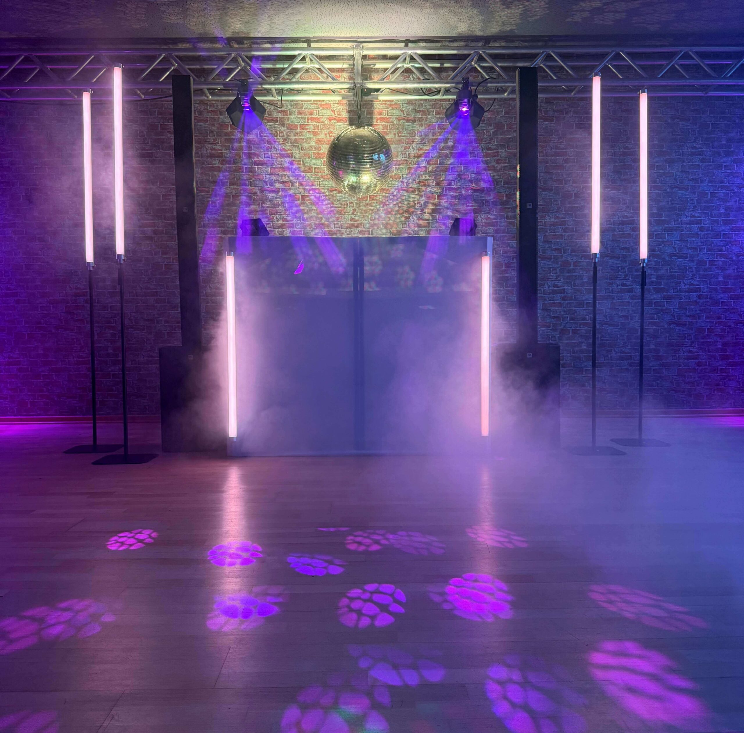 Tanzflächenbeleuchtung mit violetten Lichteffekten und Haze bei einer Hochzeit
