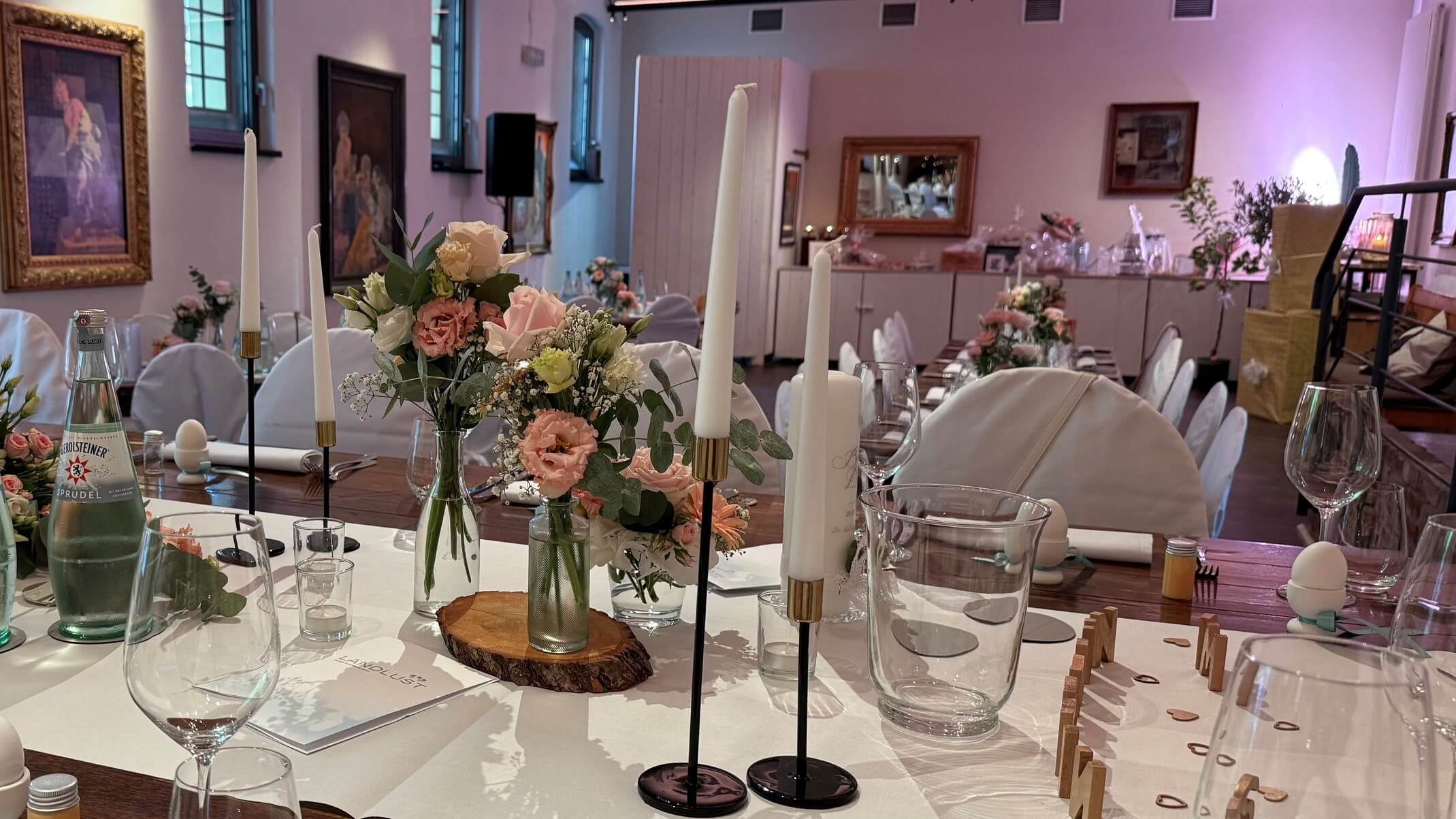 Festlich gedeckte Hochzeitstafel mit rosafarbener Blumendekoration in der Landlust Burg Flamersheim